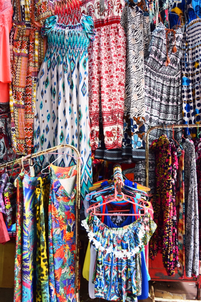 lots of colored clothes displayed  on a hawker's shop in ciudad del este, paraguay